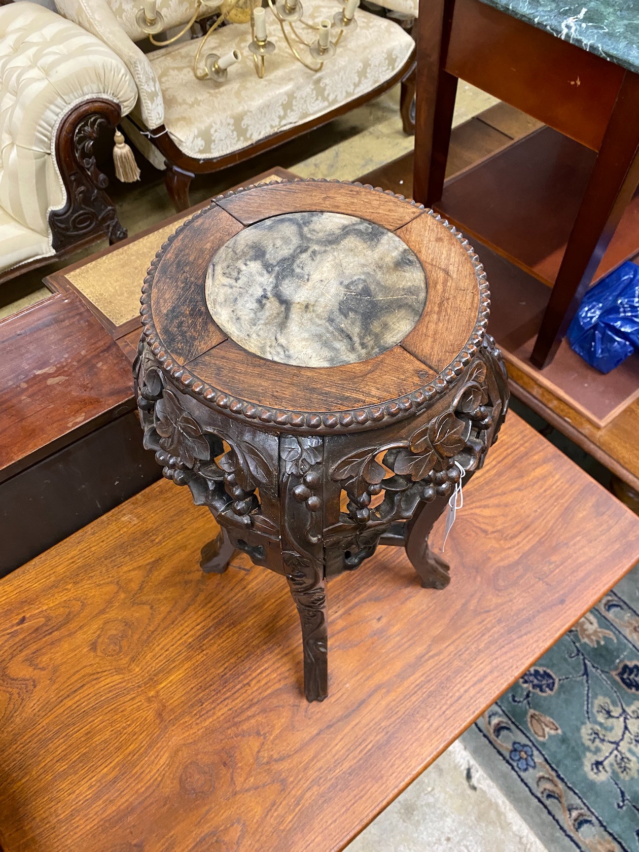 A Chinese circular carved hardwood marble topped jardiniere stand, height 62cm